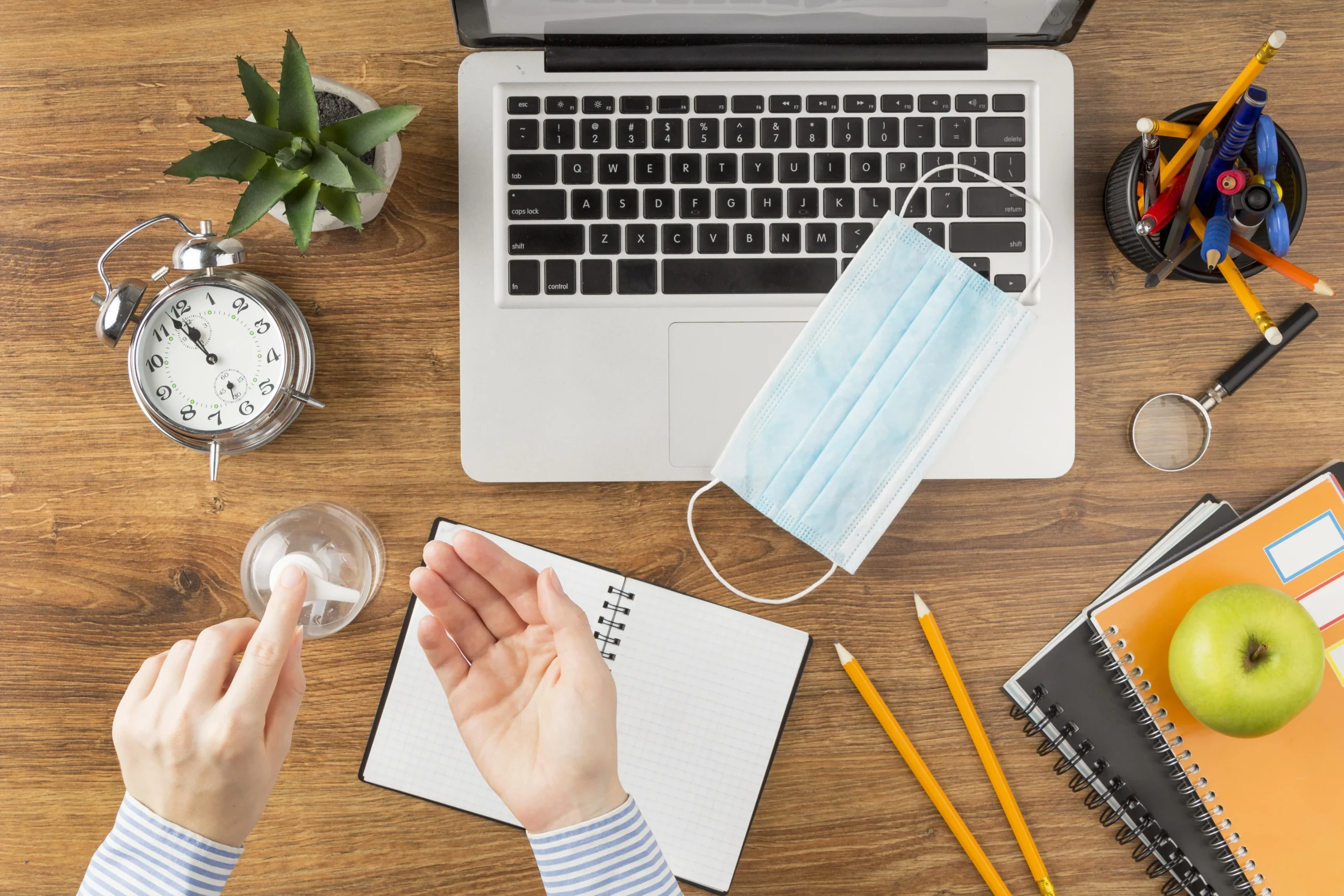 Student using disinfectant while working on desk